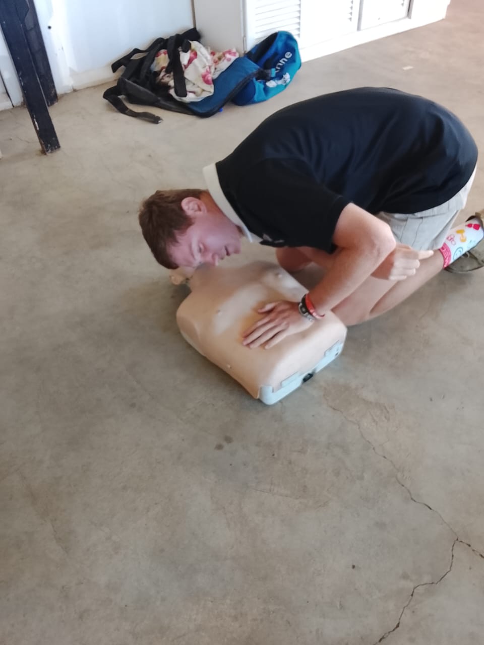 Student practising rescue breathing technique on a CPR mannequin during first aid training